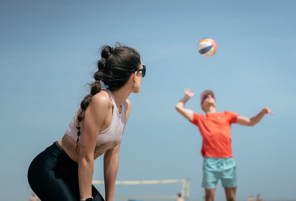 Jugadores de nivel intermedio mejorando sus habilidades en vóley playa
